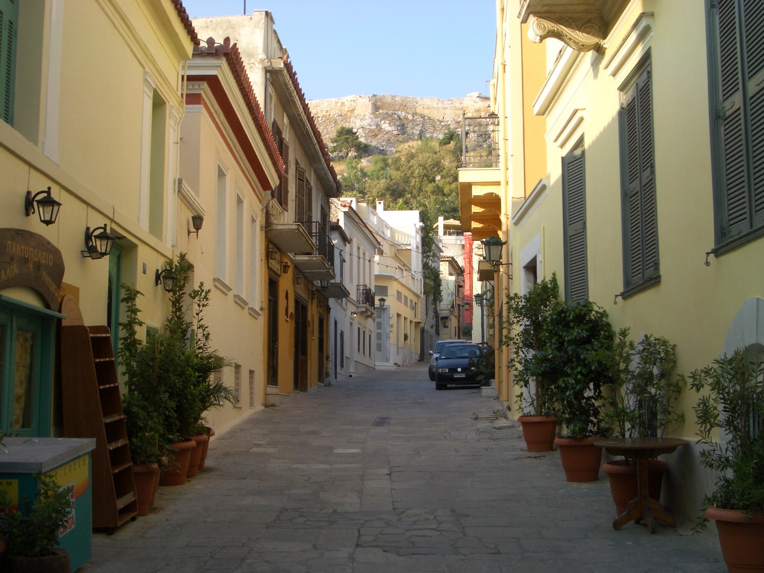 Traditional stone street in the Plaka neighborhood of Athens with the Acropolis rock visible above